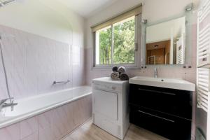 a bathroom with a sink and a tub and a mirror at Les Terrasses du Palais in Vannes