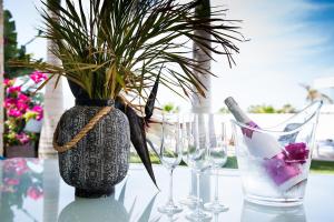 a vase with a plant and two glasses on a table at Villa Caleta Golf in Adeje