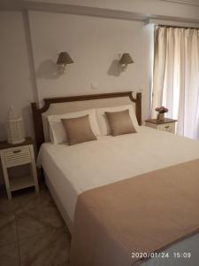 a bedroom with a large bed with white sheets and pillows at Bellarias House in Nydri
