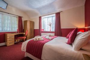Un dormitorio con una cama grande y un escritorio y una ventana. en Daish's Hotel, en Shanklin 62 fotos más