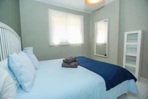 1 dormitorio con 1 cama blanca con sábanas y almohadas azules en Luxury Cayetana, by Comfortable Luxury en Corralejo