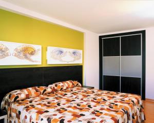 a bedroom with a bed and a yellow wall at Sol y Sombra in Benidorm
