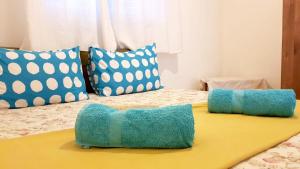 ein Bett mit zwei blauen Kissen darüber in der Unterkunft Tabor Land Guest House in Kefar Qish