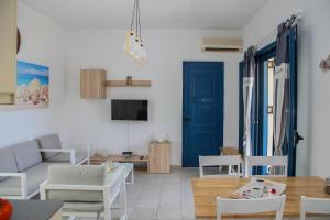 a living room with a couch and a blue door at MMM Apartment in Makry Gialos