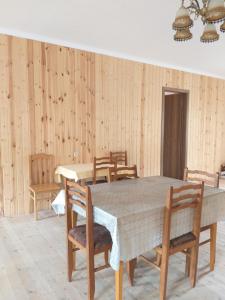 a dining room with wooden walls and a table and chairs at Guesthouse Miranda in Ushguli