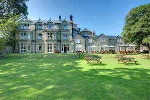 uma casa grande com mesas de piquenique em frente em Daish's Hotel em Shanklin