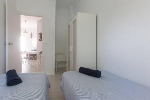 biały pokój z 2 łóżkami i korytarzem w obiekcie Bonito Apartamento Sol Tarifa, centrico y cerca de la playa w mieście Tarifa