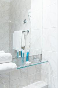 a bathroom with a glass shelf in the shower at Hotel Nawigator Szczawnica in Szczawnica
