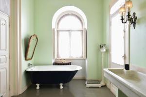 a bath tub sitting next to a window in a bathroom at Palacete Chafariz Del Rei - by Unlock Hotels in Lisbon