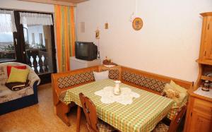 a small living room with a table and a tv at Woferlhof, Ferienhof Boxhorn in Böbrach