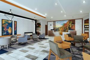 ライモンにあるLa Quinta Inn & Suites Limon by Wyndhamのロビー(椅子、テーブル、暖炉付)