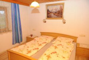 a small bedroom with a bed with a yellow comforter at Woferlhof, Ferienhof Boxhorn in Böbrach
