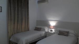 Łóżko lub łóżka w pokoju w obiekcie Hostal VILLA CARBULA
