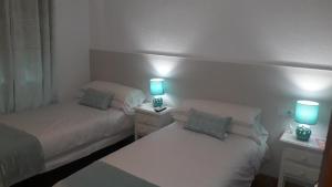 Łóżko lub łóżka w pokoju w obiekcie Hostal VILLA CARBULA