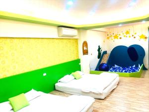 2 Betten in einem Zimmer mit einem Spielbereich in der Unterkunft 晚安熊-親子民宿 in Zhushan