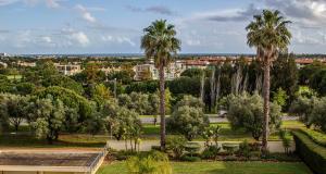 uma vista para um parque com palmeiras e edifícios em Apartamento Vista Golfe Mar Vilamoura em Vilamoura