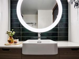 シドニーにあるノボテル シドニー ダーリング スクエアのバスルーム(白い洗面台、鏡付)