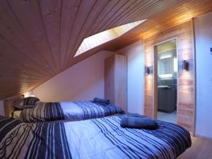 two beds in a bedroom with a wooden ceiling at Serre Che Chalet in Briançon