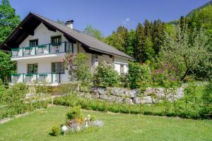 una casa con una pared de piedra frente a un patio en Grundlwald Ferienwohnungen, en Bad Aussee