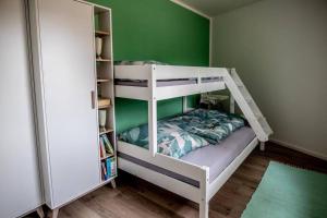 Litera en habitación con pared verde en Ferienwohnung TinyBeach en Lubmin
