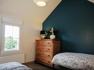 1 dormitorio con vestidor y pared azul en Le petit Mérinos - Rambouillet -, en Rambouillet