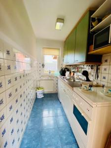 a kitchen with white cabinets and blue tile floors at kleine Seemöwe in Zingst