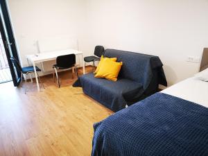 a bedroom with a blue couch and a yellow pillow at City center apartment in Koper