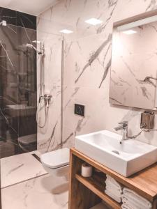 La salle de bains est pourvue d'un lavabo, d'une douche et de toilettes. dans l'établissement La Park Aparthotel, à Kudowa-Zdrój