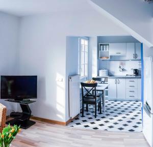 a kitchen with a table and a kitchen with white cabinets at Cinnamon villa in Palanga