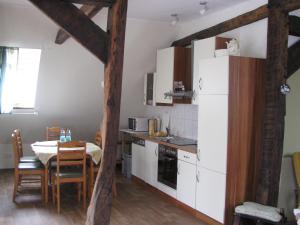 a kitchen with a table and a white refrigerator at Beautiful holiday home with sauna in Schieder-Schwalenberg