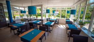 ein Restaurant mit blauen Tischen, Stühlen und Fenstern in der Unterkunft De Heek in Valkenburg