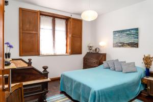 a bedroom with a blue bed and a piano at Vivenda MiraSerra in Santana