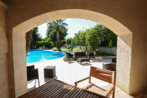 an archway over a patio with a swimming pool at Masseria La Brunetta in Massafra