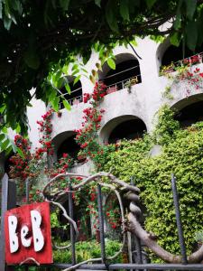 洛索內的住宿－Affittacamere Casa Archi，一座花卉建筑和标牌上写着bc的标志