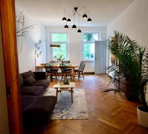 una sala de estar con un sofá y una mesa en 110 qm Ferienwohnung Stadtvilla Halberstadt - Dem Tor zum Harz, en Halberstadt