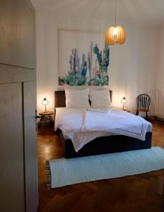 a bedroom with a bed with a painting on the wall at 110 qm Ferienwohnung Stadtvilla Halberstadt - Dem Tor zum Harz in Halberstadt