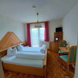 Un dormitorio con una cama, una mesa y una silla. en Landgasthof Hasbauer, en Klein Sankt Paul