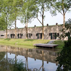 un antiguo edificio junto a un cuerpo de agua en Fort Resort Beemster, en Zuidoostbeemster