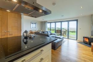 a kitchen and living room with a couch at Stargazy in St. Agnes