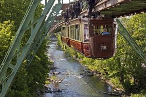 a cable car traveling over a river on a bridge at Nettes, gemütliches Apartment in Wuppertal