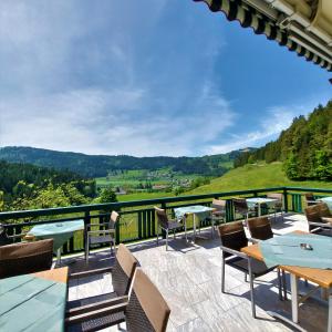 a patio with tables and chairs and a view of the mountains at Landgasthof Hasbauer in Klein Sankt Paul