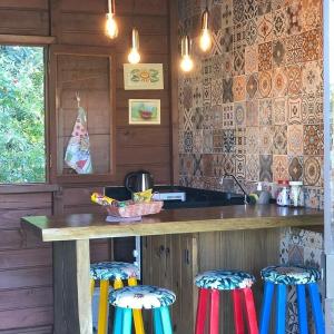 a kitchen with a counter and stools in a kitchen at Cabana Encantos da Lagoa in Imbituba