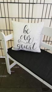 a pillow that says be our guest sitting on a bench at Apartment Am Paradies - 10 Minuten Fußweg zur Innenstadt in Limburg an der Lahn