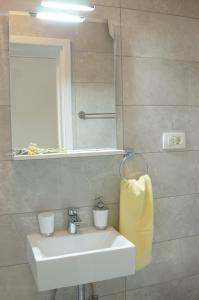 een badkamer met een witte wastafel en een spiegel bij NEW comfortable Apartment Vesna in Hvar