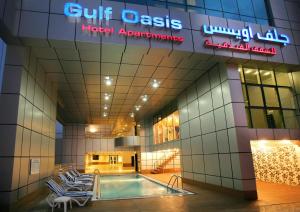 Gulf Oasis Hotel Apartments Fz LLC في دبي: مسبح في بهو الشقق الفندقية