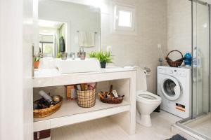 a bathroom with a sink and a washing machine at Luxurious Beach House, feels like home in Alexandroupoli