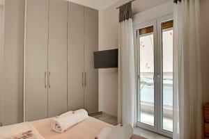 a bedroom with a bed and a sliding glass door at NOURI APARTMENT in Corfu