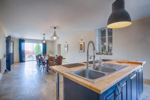 a kitchen with a sink and a dining room at La maison d'Hana in Saint-Bonnet-de-Valclérieux
