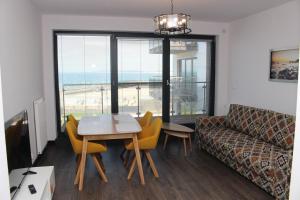 salon ze stołem, krzesłami i kanapą w obiekcie Apartamenty Kropla Bałtyku w mieście Darłowo +6 zdjęć