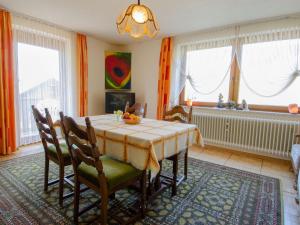 a dining room with a table and chairs and windows at Haus Harter in Wolfach